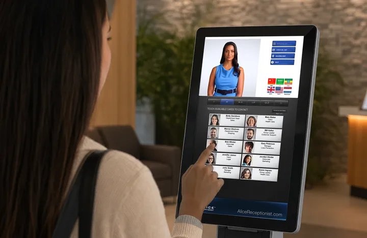 Visitor uses a virtual receptionist system in a office lobby to contact their host.